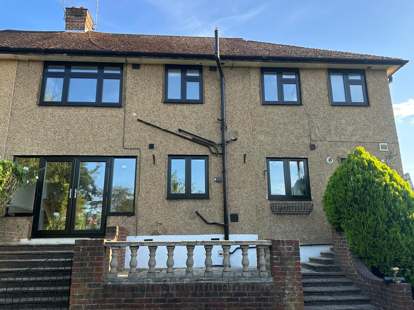 Whole-house anthracite aluminium window installation on a contemporary home
