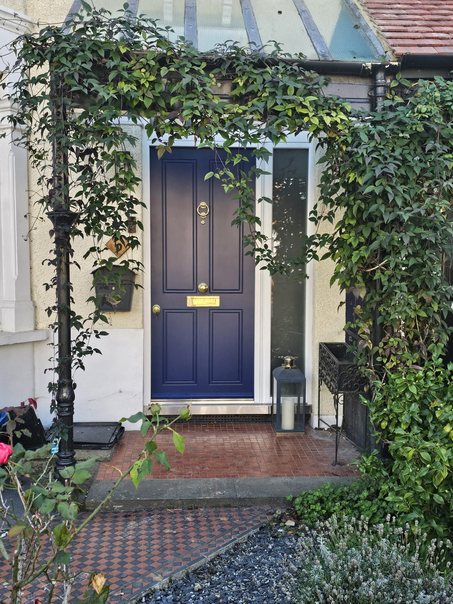 Blue steel CNC security door on vine-covered period property